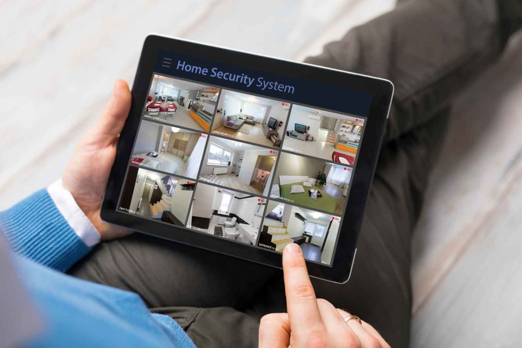 Man viewing home surveillance camera feed through smart home tablet app